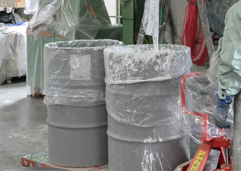 塗料をドラム缶に充填する職人